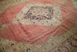 Distressed vintage Persian Jalili Tabriz carpet with aged blush red field and navy floral medallion.