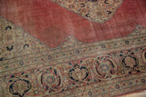 Distressed Tabriz carpet blush red field, curvilinear floral spandrel, and patterned border.