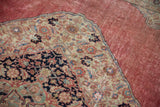 Distressed blush red field with an ornate corner spandrel on the Vintage Jalili Tabriz carpet.