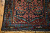Lilihan runner corner, raspberry red floral field, sky blue borders, low pile texture, and cream fringe.