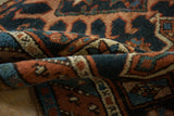 Antique Karaja rug close-up: hand-knotted geometric pile in indigo, rust, and ivory.
