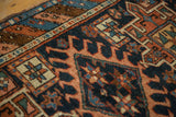 Intricate indigo and rust geometric starbursts, floral motifs on antique Karaja rug.