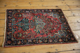 Bottom corner detail of vintage rug, showing palmette main border, dusty rose red field, and secured ends.
