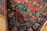 Vintage Mohajeran Sarouk rug's deep rose field, navy palmette border, and soft low pile texture.