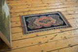 Secured side of the antique Senneh rug mat, showing dark indigo and blush tones.
