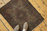 Ornate Kerman rug with central medallion, aged pile in ivory, cochineal red, and navy.