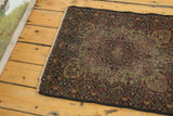 Antique Kerman rug's ornate field with ivory, red, blue floral motifs and aged pile.