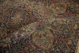 Ornate antique Kerman rug with floral tendrils, cochineal red, ivory, and mostly even wear.