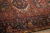 Hand-knotted vintage Karaja rug's cherry red field with serrated leaves and rich navy border.