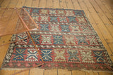 Tattered end of an antique Caucasian rug showing geometric palmette motifs.