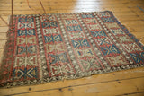 Reciprocating wave borders and geometric palmette motifs on an antique Caucasian rug corner.