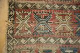 Antique Caucasian rug foundation with geometric palmettes, cherry red and sky blue, showing breaks and tatter.