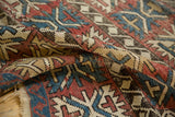 Unusual geometric palmette motif and wave border on antique Caucasian rug with red, blue, beige.