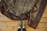 Antique Caucasian Marsali rug detail: geometric germinating plant motif in red, ivory, navy blue.