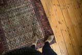 Antique Caucasian Marsali rug's ivory field with vibrant germinating plant motifs and wear.
