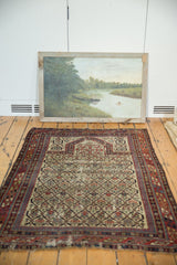 Detail of the antique Marsali rug's rich red geometric border and aged fringe.
