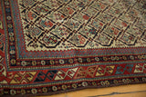 Intricate geometric borders frame germinating plant motifs on this antique Marsali rug.