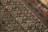 Close-up of an antique Marsali Caucasian rug's geometric plant motif and visible wear.