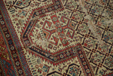 Visible threadbare areas and intricate geometric motifs on a section of antique Caucasian rug.