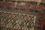 Visible pile wear and detailed geometric patterns on an antique Caucasian Marsali rug.