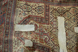 Antique Marsali rug close-up showing geometric patterns, areas of wear, and white fabric markers.