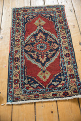Vintage Heriz rug mat showing even wear across its oversized navy medallion and cherry red field.