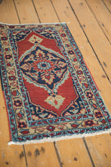 Angled view of a vintage Persian Heriz rug highlighting its oversized central medallion and borders.