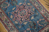 Vintage Tabriz rug's secured end with blush and ivory floral border against a blue field.
