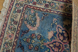 Visible floral bouquets, areas of old painting on the blue field of the vintage Tabriz rug.