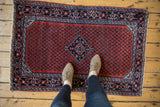 A person's perspective looking down at a vintage Engelas rug, showing its scale and full pile.