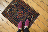 Borchalou rug corner, navy field with blush vine and zig-zag borders, plus fringe.