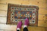 Antique Kurdish geometric rug's blue, red, and ivory double medallion and border, with feet.