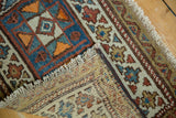 Hand-knotted corner of antique Kurdish rug, showing geometric pile, fringe, and tightly woven back.