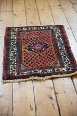 A hand-knotted Persian Engelas mat with a traditional design in rusty red and navy blue.