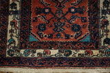 Low, even pile on the corner of a vintage Engelas rug with a detailed ivory floral border.
