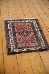 Angled view of a vintage Engelas rug showing the reciprocating wave motif border and central medallion.