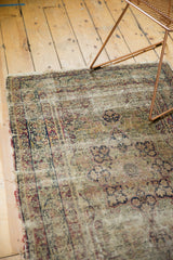 Storied antique Kerman rug field, showcasing faded cochineal red floral vinery and threadbare pile.