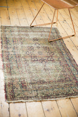 Hard-worn edge and tattered fringe of an antique Kerman rug, showing vinery border.