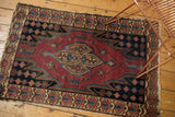 Sharply serrated zig-zag design and floral border in red, blue, beige on Vintage Malayer rug.