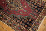 Cherry red serrated field, dark blue floral border, and frayed edge of a vintage Malayer.