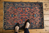 Persian Lilihan rug corner with tattered fringe, navy border, and blush floral motifs.