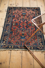 Vintage Lilihan rug corner, faded raspberry red field, navy blue border, intricate vinery, and tatter.
