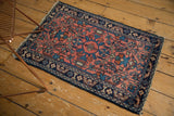 Vintage Lilihan rug corner with visible fringe tatter and rich navy floral border.