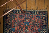 Vintage Lilihan rug corner detail, showing worn fringe, navy border, and floral patterns.