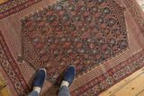 Antique Afshar rug: intricate field of botehs and seed motifs in navy, madder red, ivory.