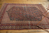 Antique Afshar rug's intricate boteh circuitry, featuring navy, red, and ivory tones.