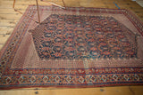Intricate geometric border and interconnected navy, madder boteh pattern on antique Afshar rug.