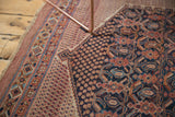 Antique Afshar rug's intricate geometric patterns, navy, madder root, and diminutive seed botehs.