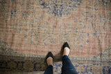 Distressed Vintage Oushak carpet with pale blush, beige, and faded cobalt blue vinery.