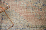 Hand-knotted Oushak rug, showing distressed pile texture with dusty blush and cobalt blue.